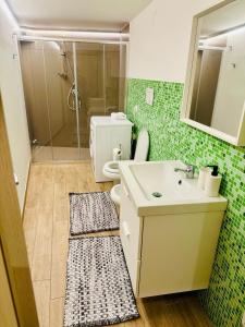 a bathroom with a sink and a toilet and a shower at Holiday House Valpiè in Avola +37 photos