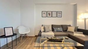 a living room with a couch and a table at Pentelis Cozy 58sqm apt in Paleo Faliro in Athens