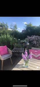 un vase de fleurs violettes assis sur une terrasse en bois dans l'établissement Designerhaus Meerblick, à Surendorf