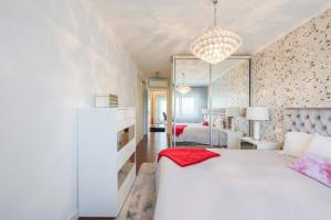 a bedroom with a white bed and a living room at Glicinias Guest House, Free garage - Aveiro in Aveiro