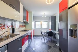 una cocina con armarios rojos y azules y una mesa. en Glicinias Guest House, Free garage - Aveiro, en Aveiro