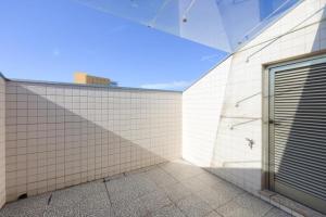 una pared de ladrillo blanco con una puerta en el lateral de un edificio en Glicinias Guest House, Free garage - Aveiro, en Aveiro