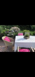 une table et des chaises avec des coussins roses sur la terrasse dans l'établissement Designerhaus Meerblick, à Surendorf