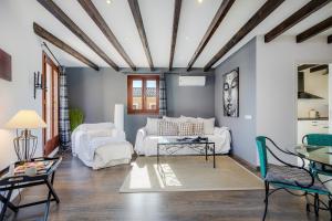 una sala de estar con 2 sofás blancos y una mesa. en Duplex Can Roses, en Moscari