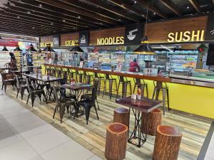 a restaurant with tables and stools in a store at Super Luxury 2 BR Apartment in Five Star Colombo City Centre in Colombo