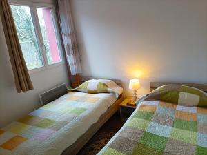 - une chambre avec 2 lits et une fenêtre dans l'établissement Charmante Maisonnette indépendante avec parking 5 mn Rouen, à Franqueville-Saint-Pierre