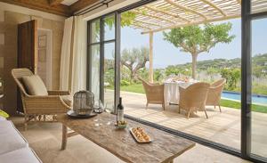 a living room with a table and chairs and a patio at Château de la Messardière in Saint-Tropez