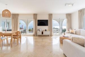 ein weißes Wohnzimmer mit einem Tisch und einer Couch in der Unterkunft 2421 Villa Joya de Guadalupe in Manilva