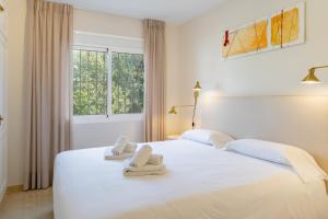 ein weißes Bett mit zwei Handtüchern darauf in der Unterkunft 2421 Villa Joya de Guadalupe in Manilva + 41 Fotos