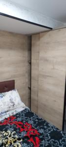 a bed in a room with a wooden wall at Studio lea in Ihaddadem