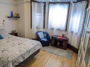 um quarto com uma cama, uma cadeira e uma janela em 2 Bedroom Family & Pet Friendly Character Building em Winnipeg