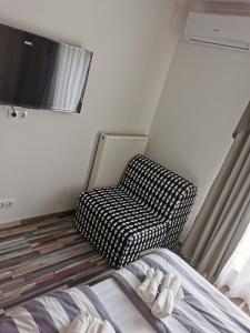 Habitación con cama, silla y TV. en Duna Riverside en Dunakeszi