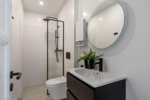 une salle de bain avec un lavabo et un miroir et des toilettes dans l'établissement The Met by Zoia Living, à Athènes 103 autres photos