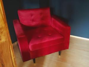 una silla roja está sentada en una habitación en THE BLACKTAGON Cozy Room en Frankfurt