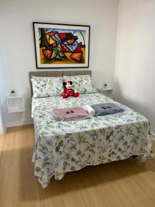 a teddy bear sitting on a bed in a bedroom at Apto frente mar 2 suítes in Rio de Janeiro