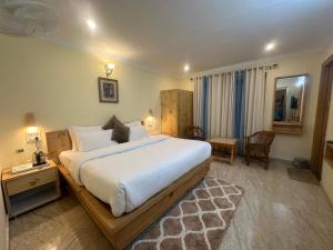 a bedroom with a large white bed in a room at HighField Villa in Kanatal