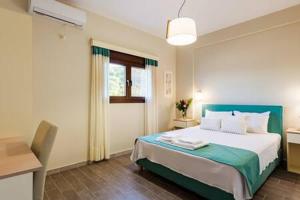 1 dormitorio con 1 cama grande y cabecero azul en Seaside Summer Bliss - Aurora Luxury Pool Paradise, en Petalidi