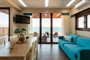 sala de estar con sofá azul y mesa en Seaside Summer Bliss - Aurora Luxury Pool Paradise, en Petalidi