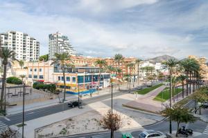une rue de la ville avec des palmiers et des bâtiments dans l'établissement Costa Blanca Holiday Rental Amalia I, à El Campello