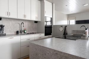 a kitchen with white cabinets and a granite counter top at Apartment Bliss in Are w. Sauna in Åre