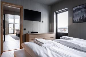 a bedroom with two beds and a flat screen tv at Apartment Bliss in Are w. Sauna in Åre