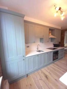 a kitchen with white cabinets and a sink at Beautiful and spacious flat in Central Shoreditch in London