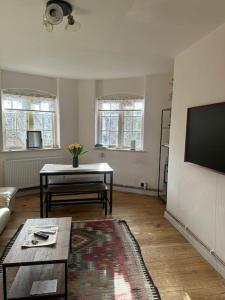 ein Wohnzimmer mit einem Tisch und einem TV in der Unterkunft Beautiful and spacious flat in Central Shoreditch in London