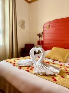 サロン・ド・プロヴァンスにあるグランド ホテル デ ラ ポステの白鳥二頭がベッドの上で心臓を形成している
