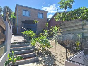 una casa con escaleras y plantas delante de ella en Bungalow tiayo, en Saint-Leu