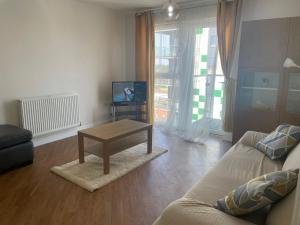 a living room with a couch and a coffee table at Dagenham 1 bed flat with views in Goodmayes