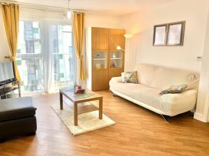 uma sala de estar com um sofá e uma mesa de centro em Dagenham 1 bed flat with views em Goodmayes