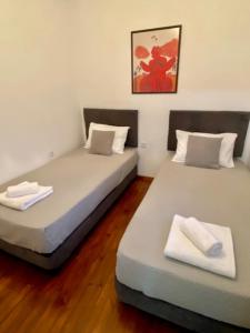 two beds sitting next to each other in a room at Zante Town Apartment in Zakynthos +6 photos