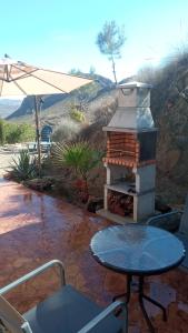 d'une terrasse avec une table et une cheminée. dans l'établissement Casa Cuatro-Vientos en Águilas, Murcia, à Águilas