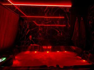 a hot tub with red lights in a room at Love Room Passion in Saint-Hilaire-de-Talmont