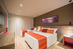 Hotel Laghetto Stilo Borges في غرامادو: غرفه فندقيه بسرير واريكه