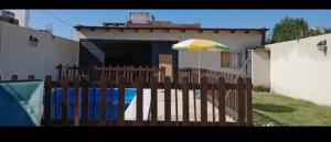 a wooden fence with an umbrella in front of a house at Apolo in General Alvarado