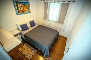 a small bedroom with a bed and a window at Chácara Atibaia com Casa na Árvore in Atibaia
