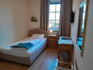 ein kleines Schlafzimmer mit einem Bett und einem Spiegel in der Unterkunft Hotel-Gasthof Opel in Heinersreuth