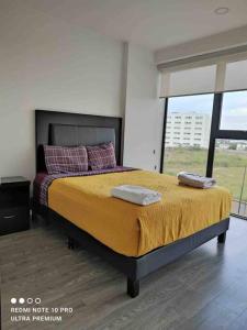 ein Schlafzimmer mit einem Bett mit zwei Handtüchern darauf in der Unterkunft Nuevo departamento en Sonata, Blank, Lomas, puebla in Lomas de Angelopolis