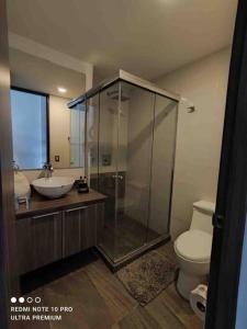 ein Bad mit einer Dusche, einem Waschbecken und einem WC in der Unterkunft Nuevo departamento en Sonata, Blank, Lomas, puebla in Lomas de Angelopolis