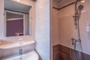 a bathroom with a sink and a shower with a mirror at Saint Georges Lafayette in Paris +17 photos