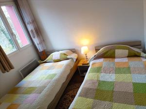 a bedroom with two beds and a window at Charmante Maisonnette indépendante avec parking 5 mn Rouen in Franqueville-Saint-Pierre