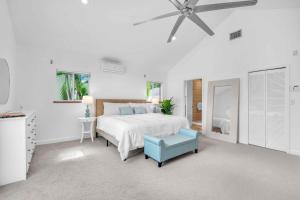 a white bedroom with a bed and a blue chair at Center Grove - Lush & Spacious & New - 3 Bedrooms in Miami