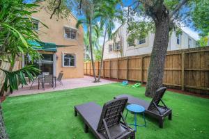 a backyard with a table and chairs and a fence at Center Grove - Lush & Spacious & New - 3 Bedrooms in Miami