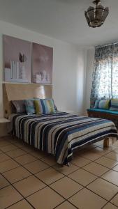a bedroom with a bed with a striped blanket at Habitación privada en casa de huespedes in Guadalajara