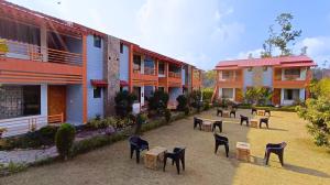 a row of chairs in a courtyard next to buildings at KK Jungle View Resort by Asapian in Kota Bāgh