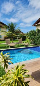 una piscina en un patio con sillas y árboles en Casa Luxo com piscina privativa próximo a Igrejinha - Com colaboradora e enxoval en Praia dos Carneiros