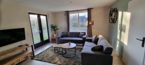sala de estar con sofá y TV en Vakantiewoning Maas en Waal 146, en Ewijk