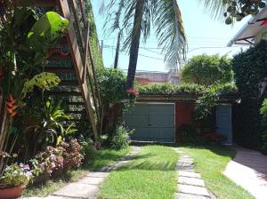 a garden with a garage and a palm tree at Suite da Fernanda in Vila Velha