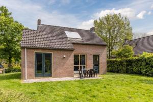 una pequeña casa de ladrillo con una mesa en un patio en Vakantiewoning Maas en Waal 146, en Ewijk